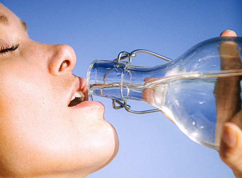 Woman drinking water to satisfy the sensation of thirst